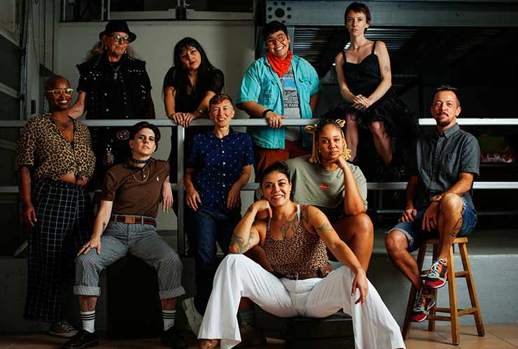 Photograph of the staff of Splinter Collective LLC posing for a staged group picture. Top Row (L to R): Sharkey; Angel; Rusty; Johanna. Bottom Row (L to R): Sam; Ryder; Raye; Nat; Monk; TC.